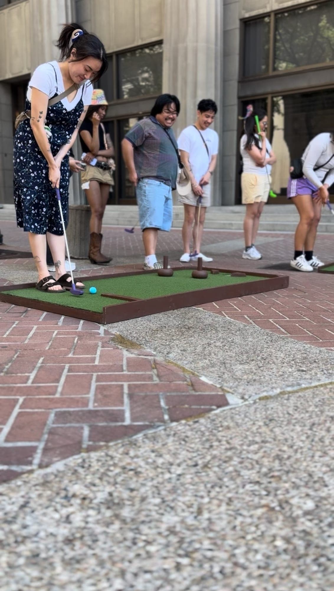 Guests putting on an indoor Putts hole
