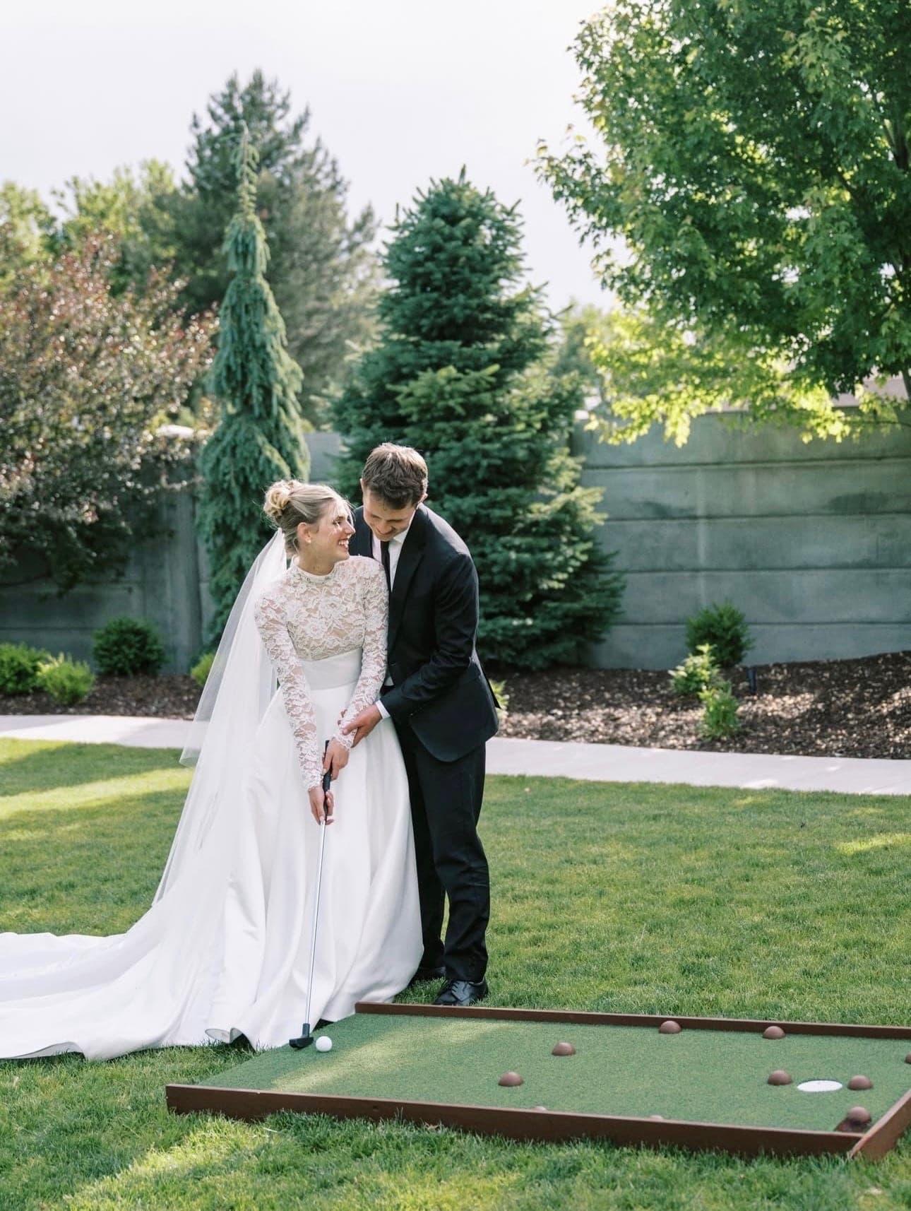 A wedding couple standing beside a Putts hole